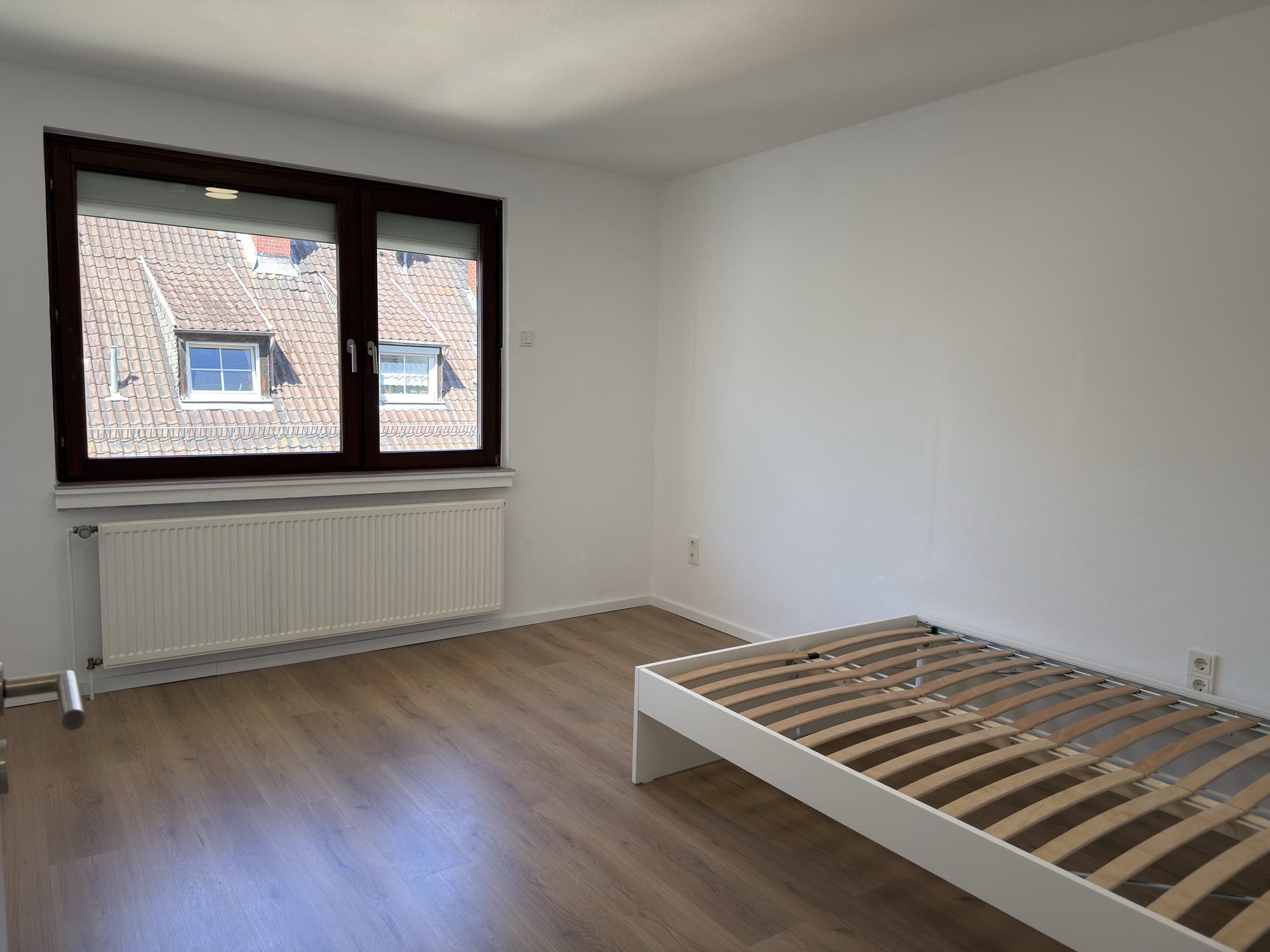 Zimmer mit Fenster und Blick über die Dächer
