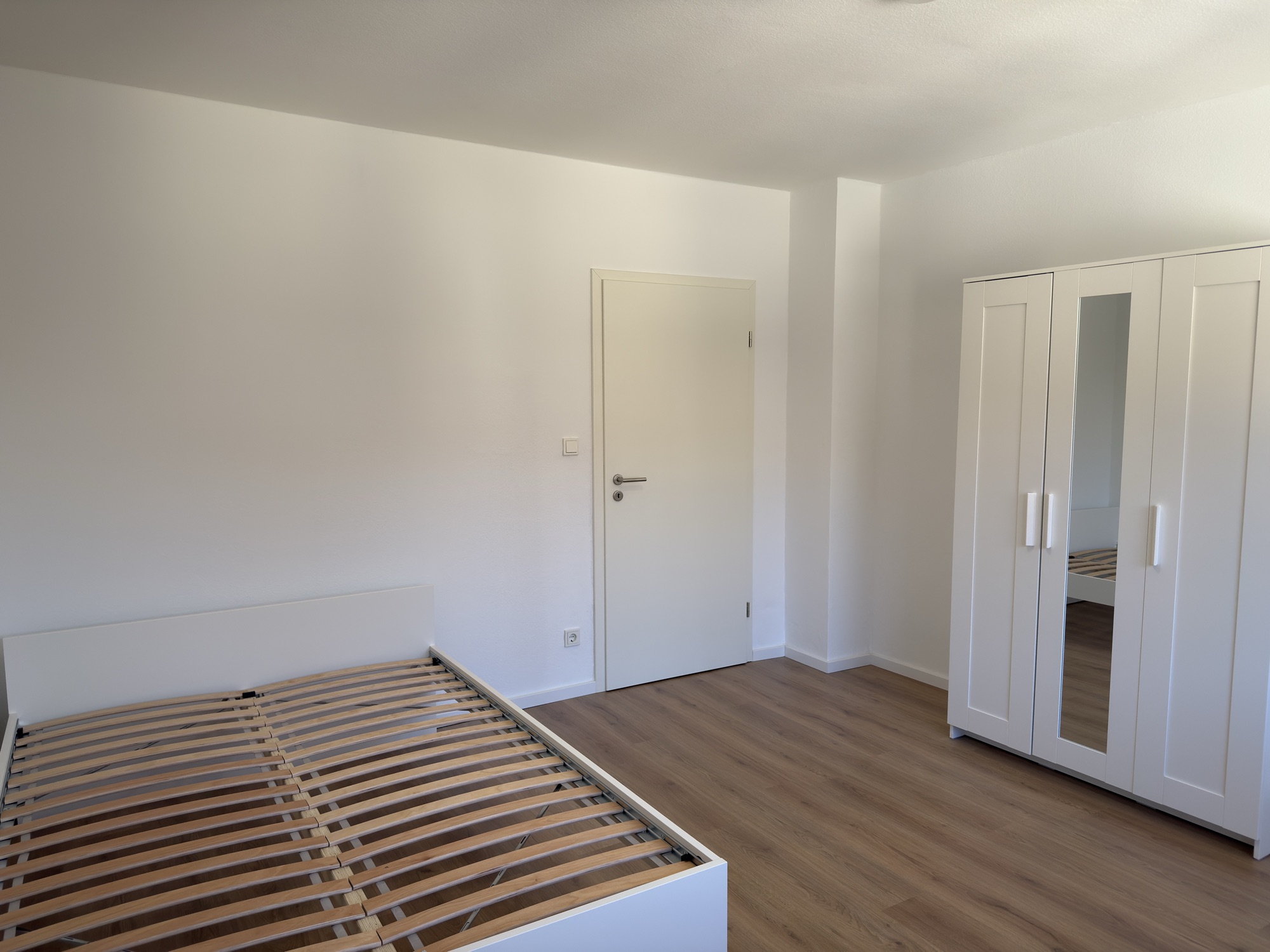 Helles Zimmer mit weißem Kleiderschrank